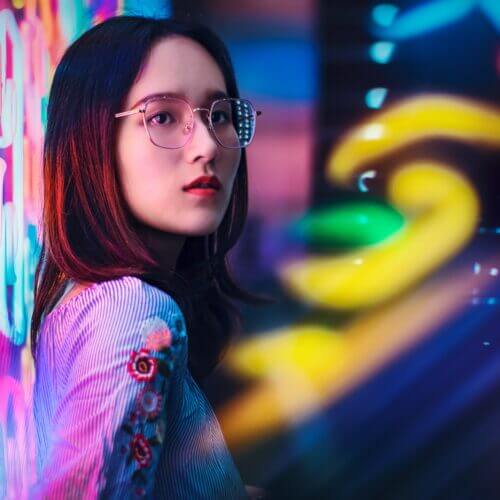 Femme avec des lunettes sur un fond de couleurs néons
