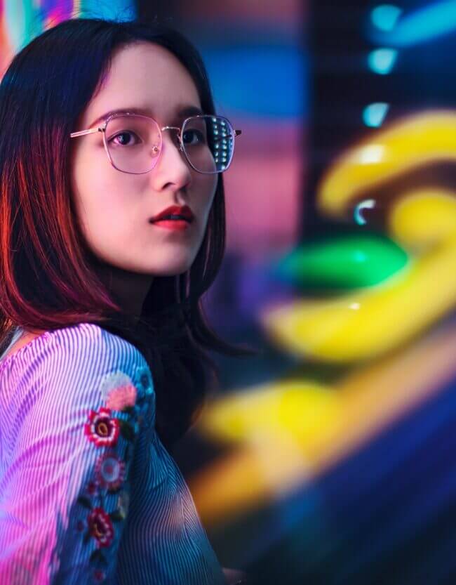 Femme avec des lunettes sur un fond de couleurs néons