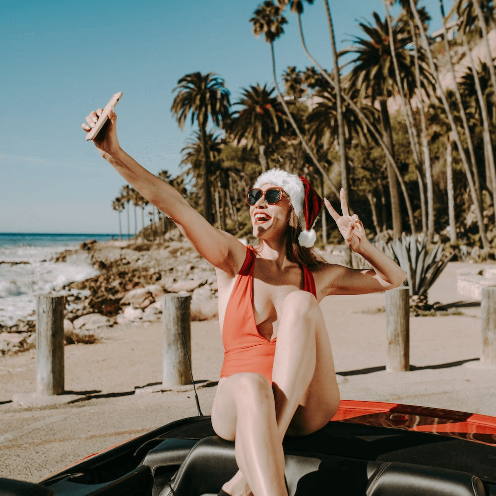 femme en maillot de bain et bonnet de père noël sur la plage